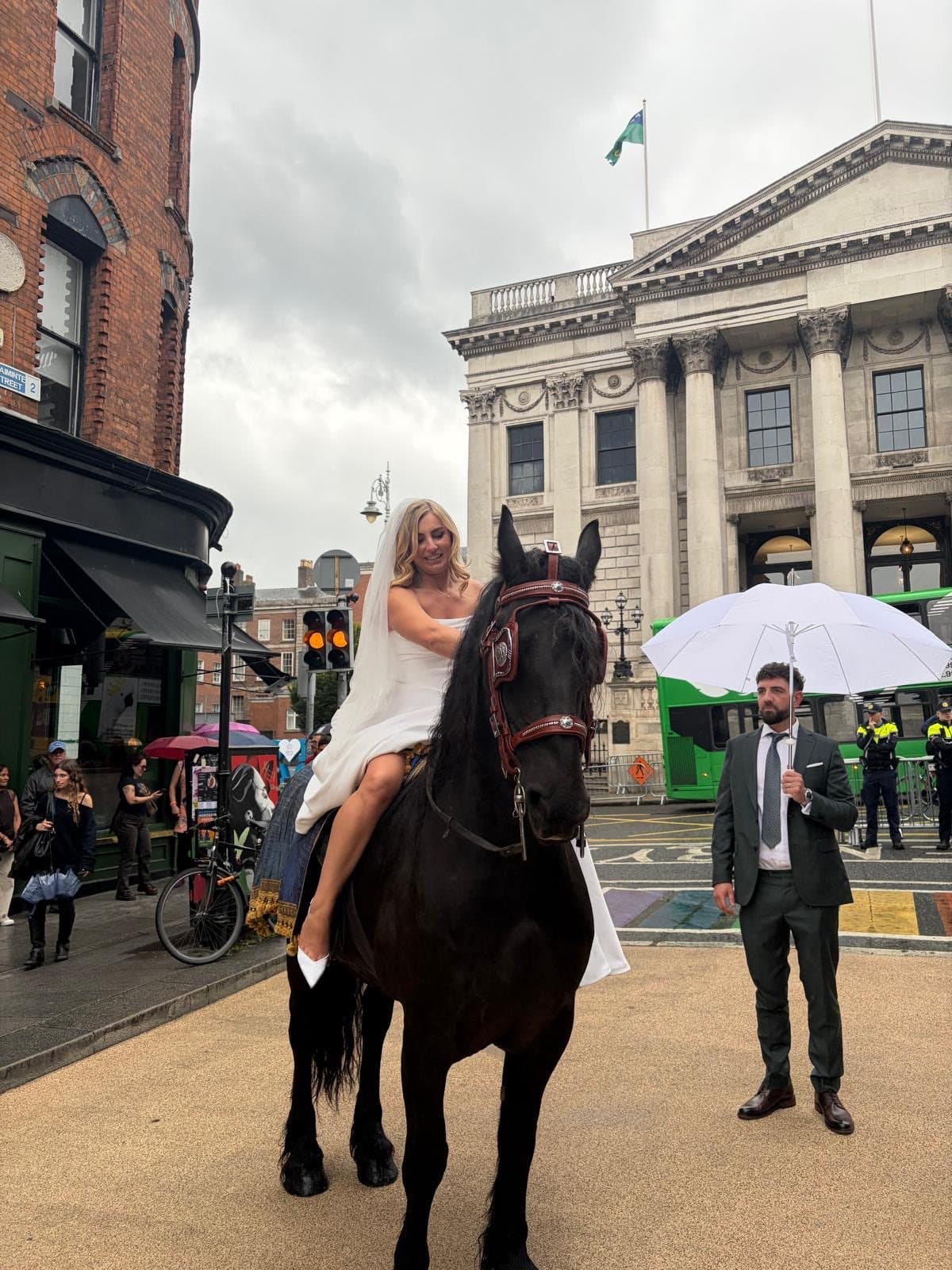 The bride on Romeo at the top of Parliament Street, with City Hall behind